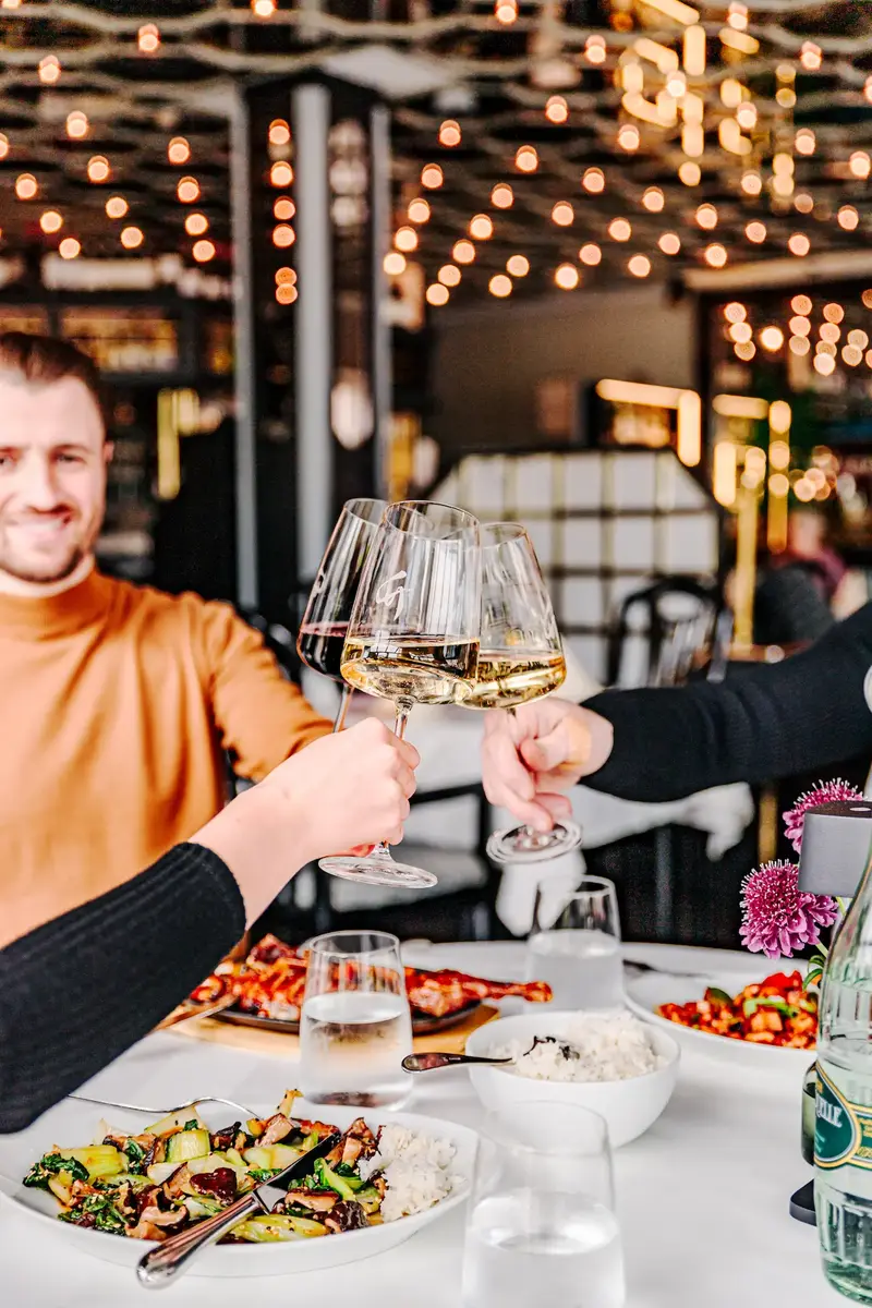 Gäste stoßen mit Wein an im Bambus Garden